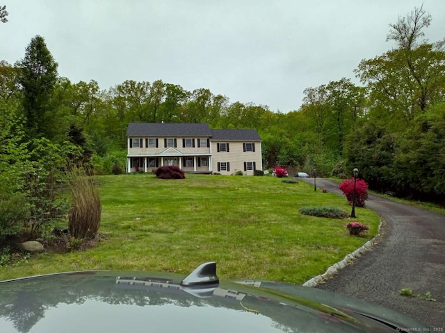 view of front facade with a view of trees and a front yard