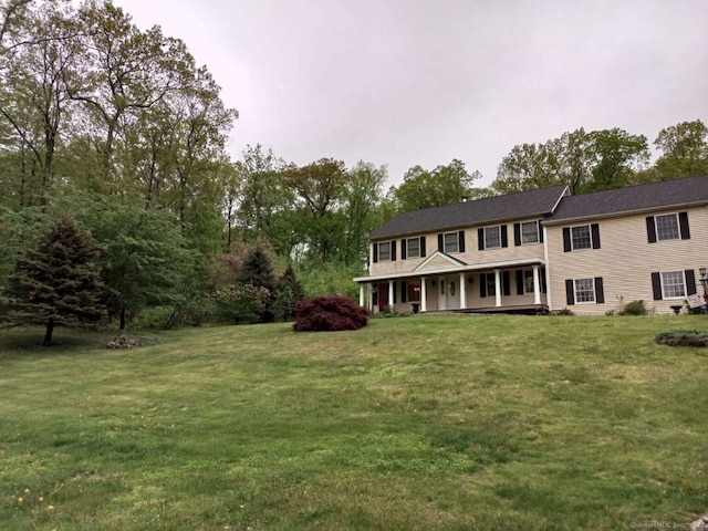 colonial home with a porch and a front yard