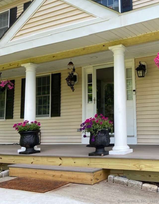 view of exterior entry featuring covered porch