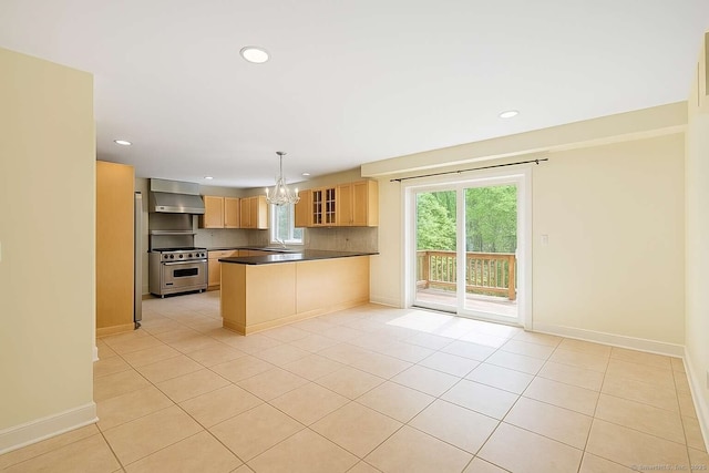 kitchen with high end range, a chandelier, recessed lighting, a peninsula, and wall chimney range hood