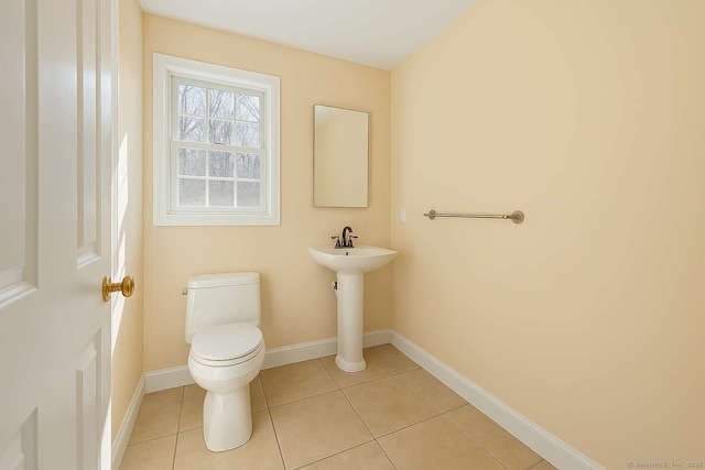 bathroom with toilet, tile patterned floors, and baseboards