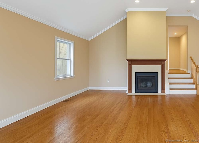 unfurnished living room with light wood-type flooring, baseboards, stairs, vaulted ceiling, and a fireplace