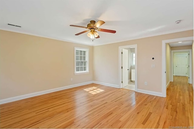 spare room featuring light wood-style flooring, baseboards, ceiling fan, crown molding, and plenty of natural light