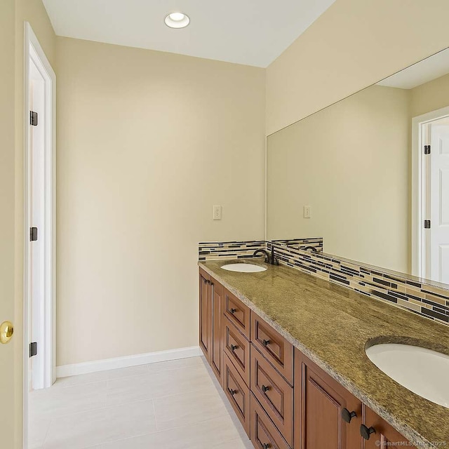 bathroom featuring double vanity, baseboards, recessed lighting, and decorative backsplash
