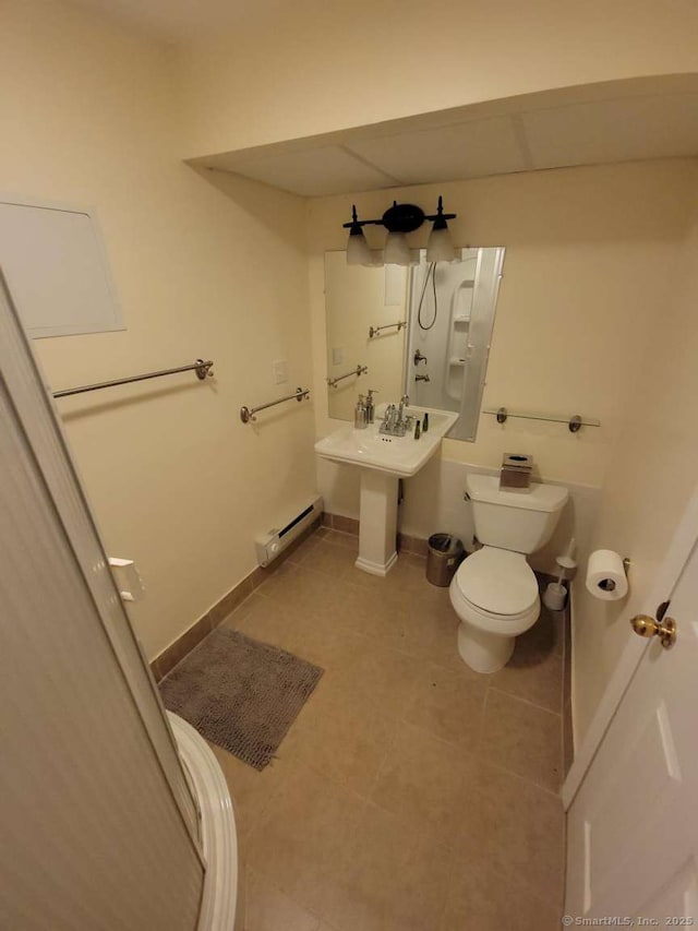 bathroom featuring toilet, tile patterned floors, baseboard heating, and baseboards