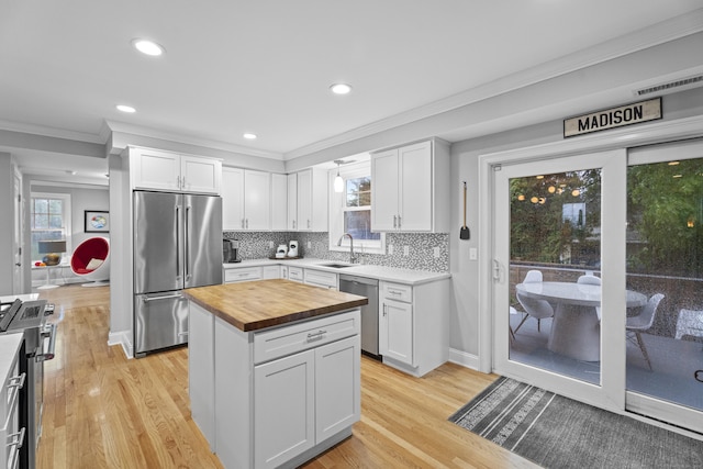 3 Arrowhead Rd, Madison, CT 06443 - kitchen with stainless steel appliances, butcher block countertops, a sink, ornamental molding, and white cabinets