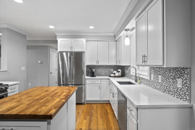 3 Arrowhead Rd, Madison, CT 06443 - kitchen featuring stainless steel appliances, wood counters, a sink, ornamental molding, and light wood finished floors