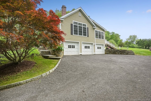 18 Beaver Dam Rd, Newtown, CT 06470 - view of home's exterior with stairway, a garage, a chimney, and driveway