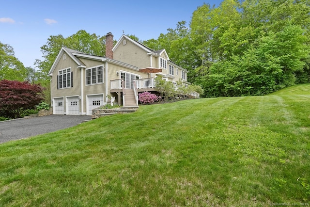 18 Beaver Dam Rd, Newtown, CT 06470 - view of side of home featuring a garage, driveway, a chimney, a wooden deck, and a yard
