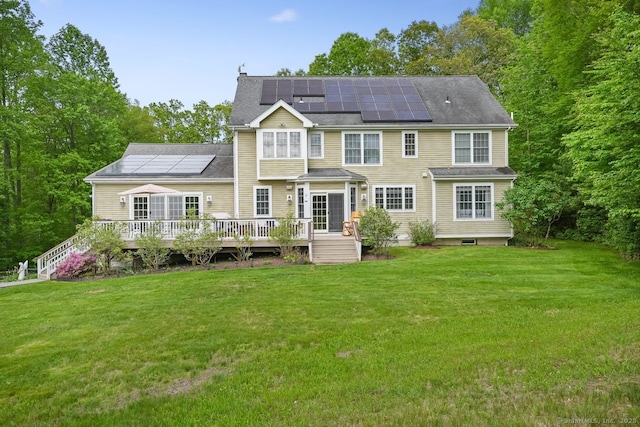 18 Beaver Dam Rd, Newtown, CT 06470 - back of property with roof mounted solar panels, a lawn, a wooden deck, and a chimney
