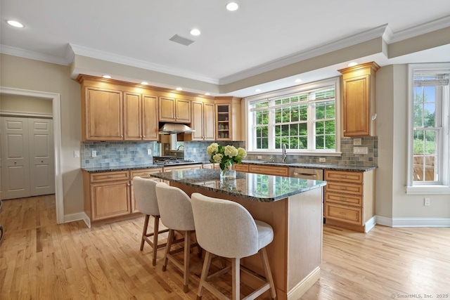 18 Beaver Dam Rd, Newtown, CT 06470 - kitchen featuring a sink, crown molding, light wood-type flooring, a breakfast bar area, and dark stone countertops