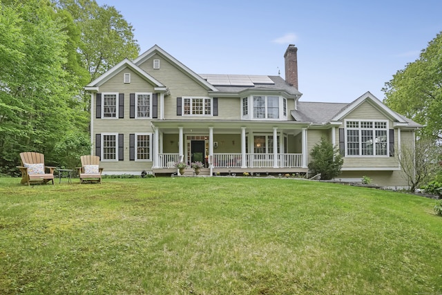 18 Beaver Dam Rd, Newtown, CT 06470 - rear view of property with a porch, a chimney, solar panels, and a lawn