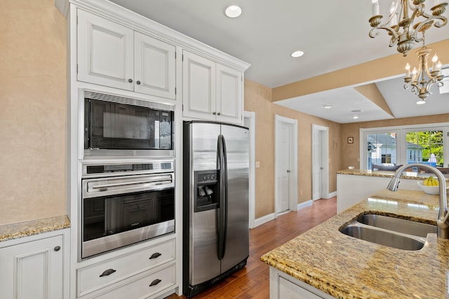 178 Shore Ave, Groton, CT 06340 - kitchen with appliances with stainless steel finishes, a chandelier, white cabinetry, wood finished floors, and light stone counters