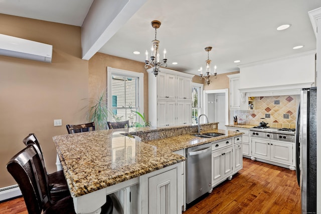 178 Shore Ave, Groton, CT 06340 - kitchen with stainless steel appliances, a chandelier, an AC wall unit, white cabinets, and a breakfast bar area