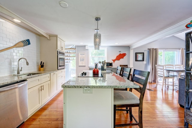 5 Quarry Rd, Stonington, CT 06355 - kitchen with appliances with stainless steel finishes, a kitchen breakfast bar, a kitchen island, light wood-type flooring, and light stone counters