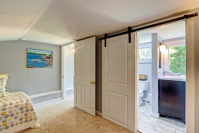 5 Quarry Rd, Stonington, CT 06355 - bedroom featuring vaulted ceiling, a barn door, ensuite bathroom, and light colored carpet