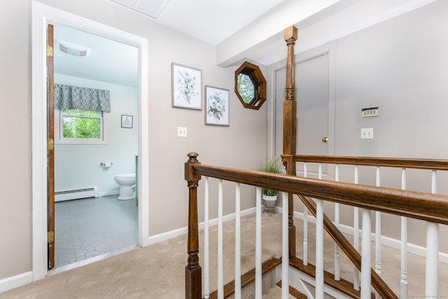 hall with a baseboard heating unit, carpet floors, baseboards, and stairway