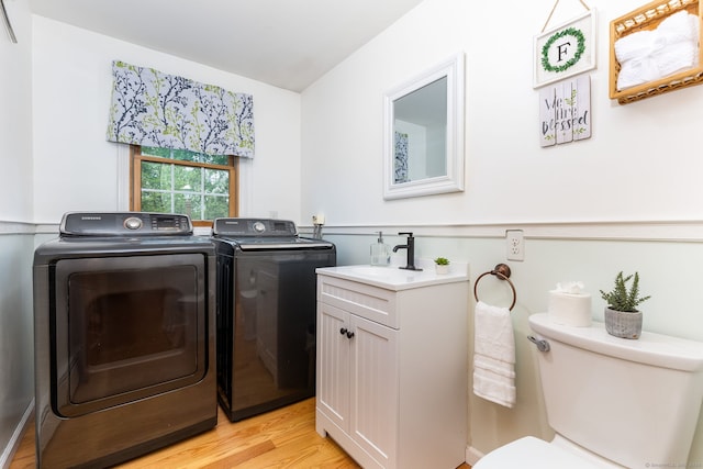 washroom with independent washer and dryer and light wood-style flooring