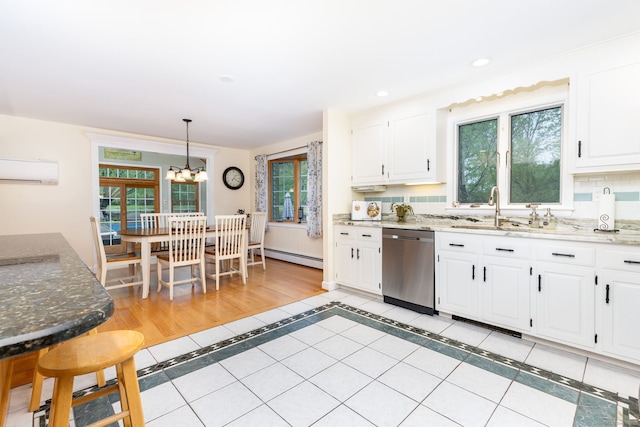 kitchen featuring stainless steel dishwasher, a sink, inlaid floor details, a baseboard radiator, and plenty of natural light