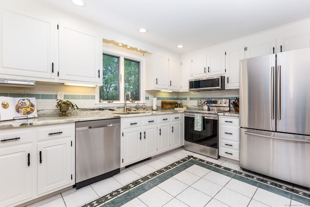 kitchen with stainless steel appliances, a sink, decorative backsplash, white cabinets, and recessed lighting