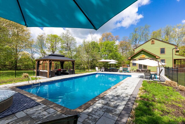 view of pool with an outdoor living space, a gazebo, a patio area, and a fenced backyard