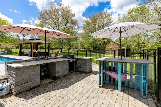 view of patio featuring a fenced backyard, a gazebo, a grill, and an outdoor kitchen