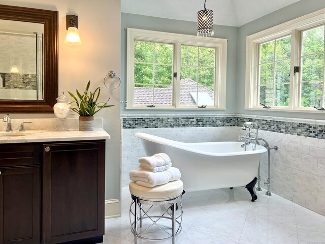 10 Woods End Dr, Wilton, CT 06897 - bathroom featuring tile walls, a soaking tub, vanity, and a wainscoted wall