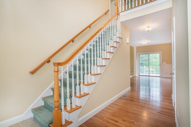 stairway with wood-type flooring and baseboards
