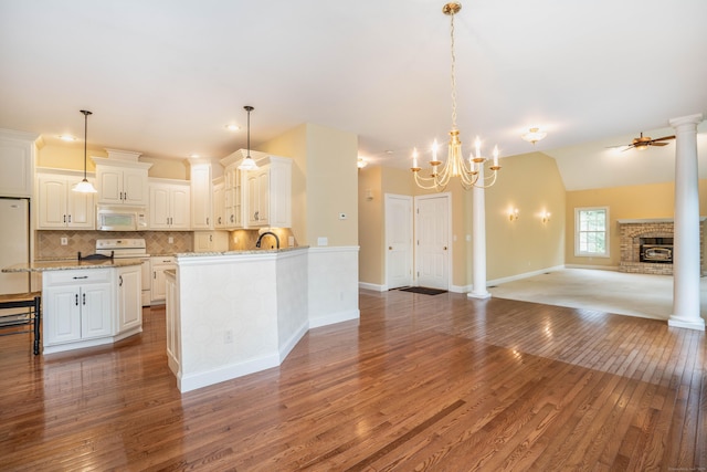 kitchen with white appliances, open floor plan, light wood-style flooring, white cabinetry, and tasteful backsplash