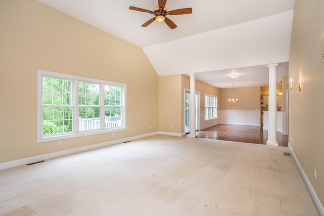 carpeted spare room with decorative columns, a chandelier, a ceiling fan, and baseboards