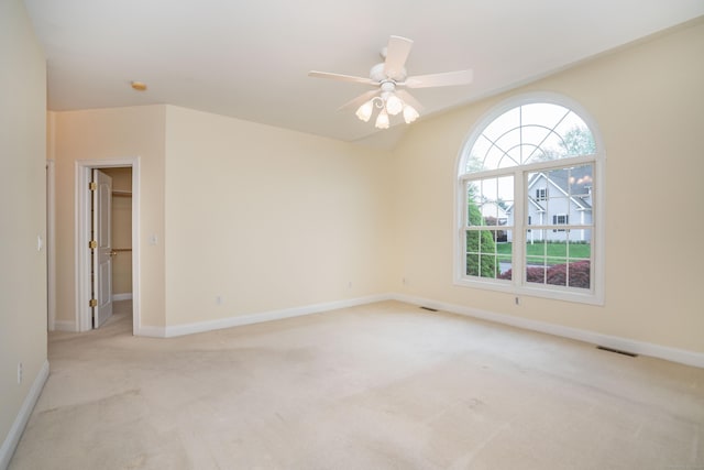 empty room featuring light colored carpet, baseboards, and a ceiling fan