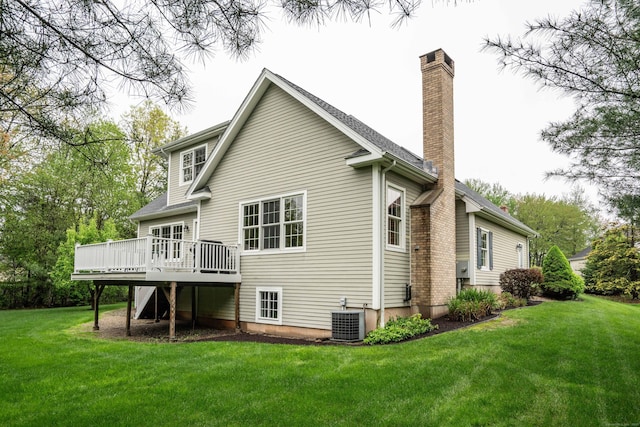 back of property with a chimney, central air condition unit, a deck, and a lawn