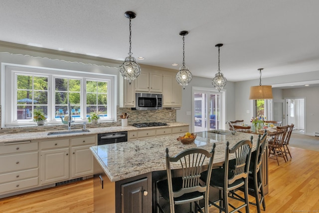 16 Cider Mill Rd, Burlington, CT 06013 - kitchen featuring appliances with stainless steel finishes, a breakfast bar, tasteful backsplash, light stone counters, and light wood-type flooring