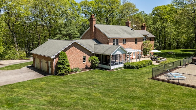 16 Cider Mill Rd, Burlington, CT 06013 - rear view of house with a sunroom, brick siding, asphalt driveway, a yard, and a chimney