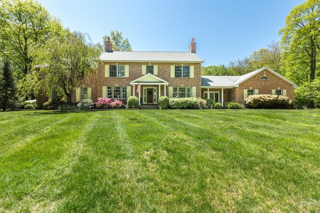 16 Cider Mill Rd, Burlington, CT 06013 - colonial inspired home with a front yard, a chimney, and brick siding