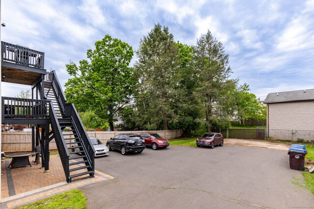 uncovered parking lot featuring stairway and fence