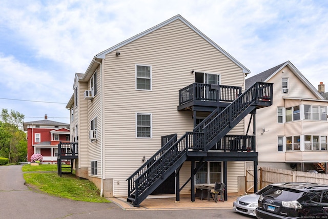 rear view of property with stairs, fence, and a wooden deck