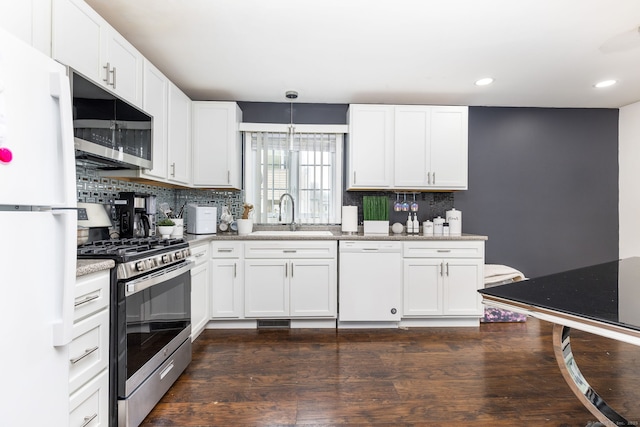 kitchen featuring appliances with stainless steel finishes, a sink, backsplash, white cabinets, and recessed lighting