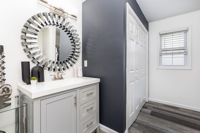 wine room featuring a sink, dark wood finished floors, and baseboards