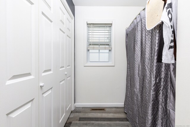 full bathroom with wood finished floors and baseboards