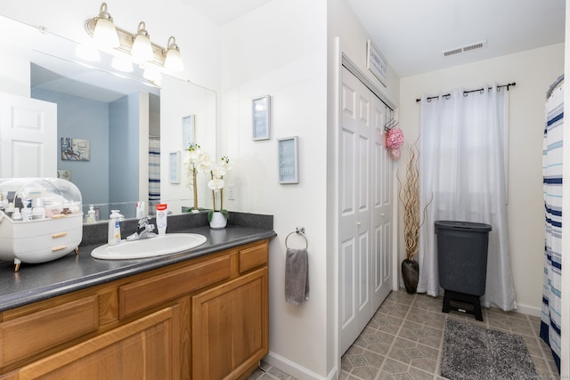 bathroom featuring vanity, baseboards, and tile patterned floors