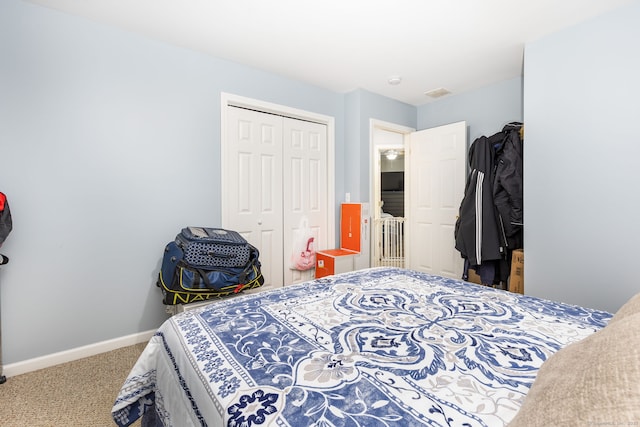 carpeted bedroom featuring a closet and baseboards