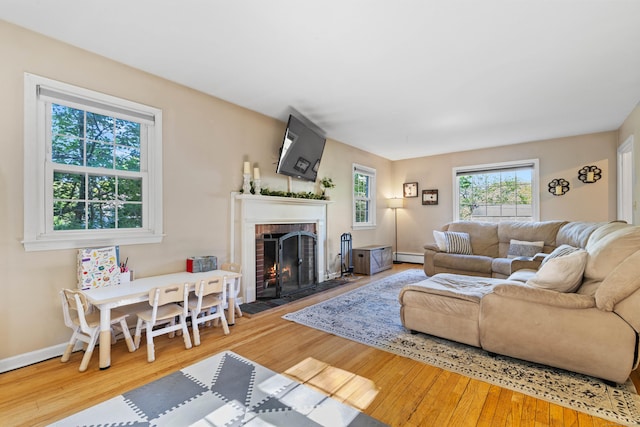 5 Willow Ln, East Lyme, CT 06333 - living room featuring baseboard heating, a fireplace, wood-type flooring, and baseboards