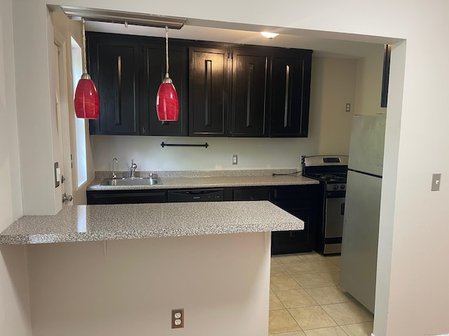 kitchen with a sink, stainless steel appliances, dark cabinets, and light countertops