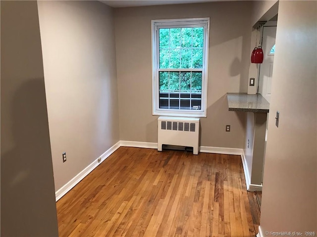 doorway featuring radiator, hardwood / wood-style flooring, and baseboards