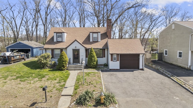 view of front of house with a chimney, asphalt driveway, an attached garage, a shingled roof, and a front lawn