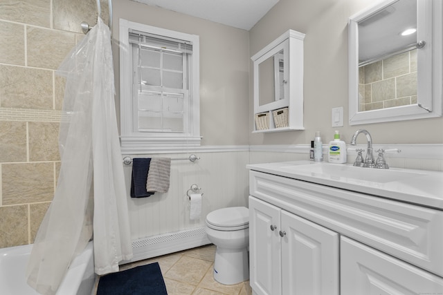 full bathroom featuring toilet, a wainscoted wall, vanity, a baseboard heating unit, and shower / tub combo with curtain