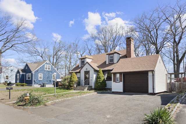cape cod-style house with a garage, a chimney, asphalt driveway, fence, and roof with shingles
