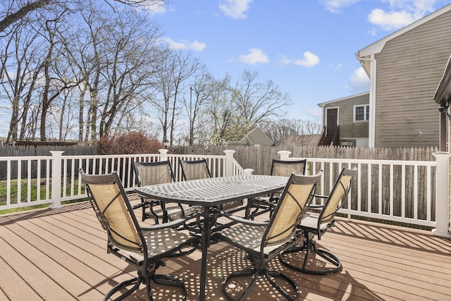 wooden terrace with outdoor dining area and a fenced backyard