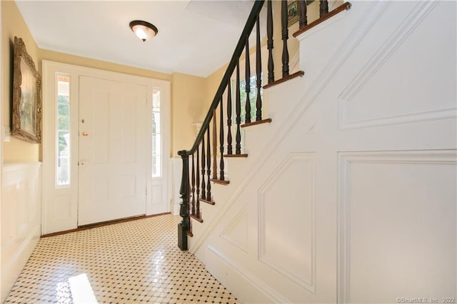521 State St, Guilford, CT 06437 - foyer entrance with a decorative wall, stairway, and a wainscoted wall